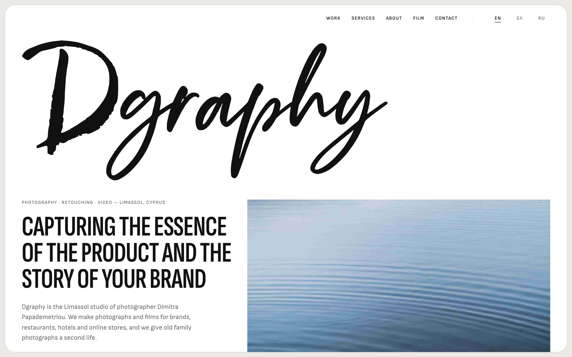 The Dgraphy homepage, with the brush-script logo above a photograph of still water